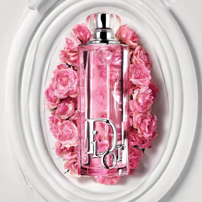 Pink perfume bottle with floral design and 'Dior' logo against a white background
