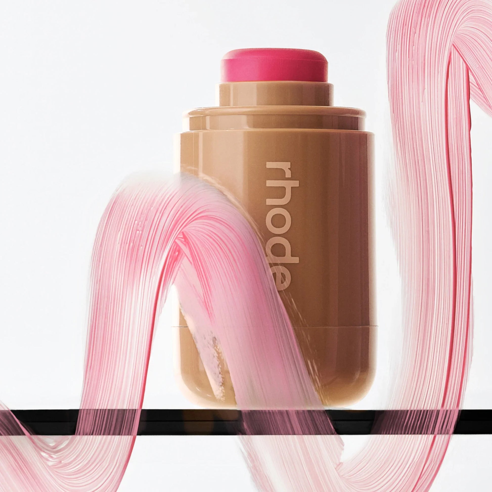 Makeup stick with pink cap and visible brand name on a white background