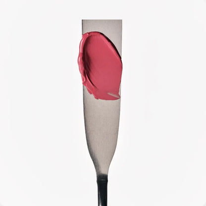 Red lip gloss on a mannequin arm with a white background